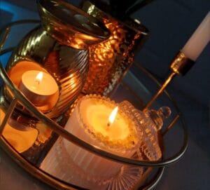 lumânare din ceară de soia aprinsă pe o masă decorată natural